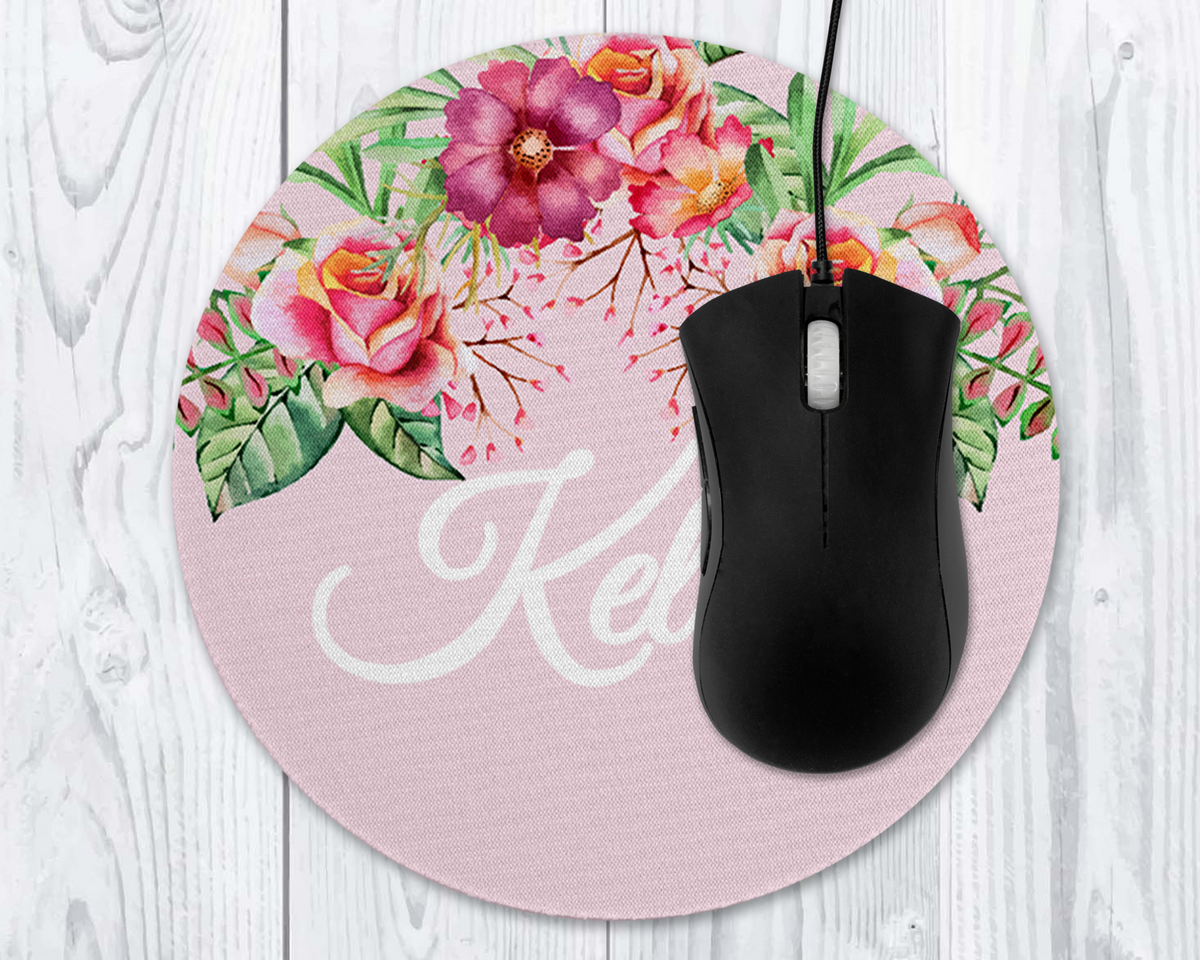 Floral mouse pad with a black mouse on a light wooden surface